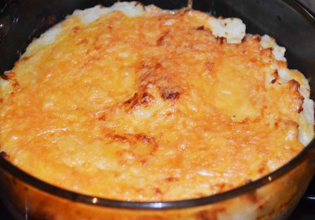 large bowl of mashed potato with melted cheese on top