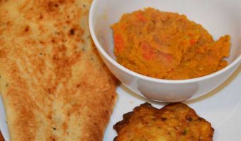bowl of dhal with nan bread and bhaji on the side