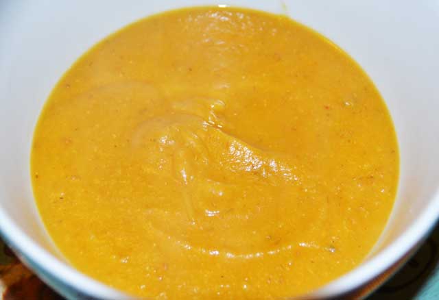 orange coloured soup with carrot, butternut squash and red lentils in a bowl