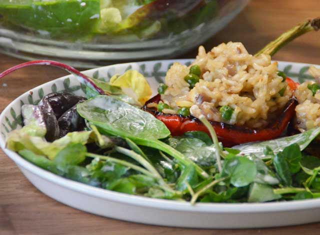 red pepper stuffed with rice on plate with salad