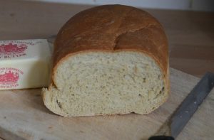 half-loaf-white-bread-on-bread-board-with-knife-and-block-of-butter