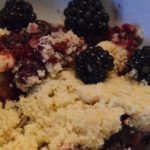 portion of blackberry crumble with whole blackberries