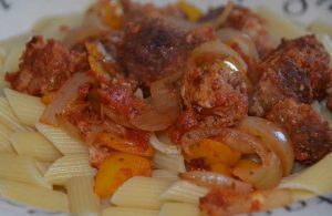 sausage, onion and peppers on a bed of pasta