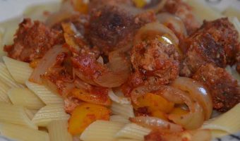 sausage, onion and peppers on a bed of pasta