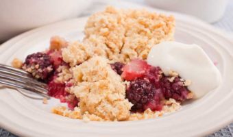 portion of apple and blackberry crumble showing fruit and crumble