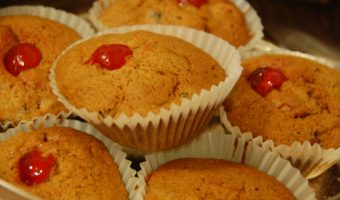 6 small brown christmas muffins with cherry in the middle