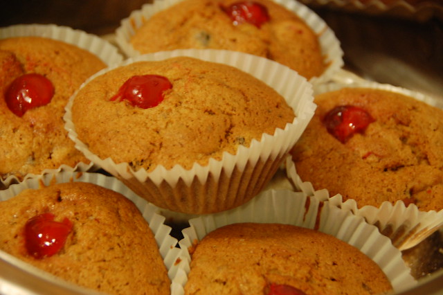 6 small brown christmas muffins with cherry in the middle