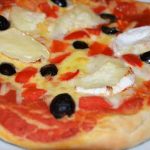 whole pizza with goats cheese and olives topping