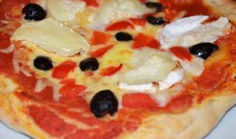 whole pizza with goats cheese and olives topping