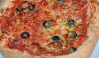 whole home made pizza with cheese tomatoe and olives