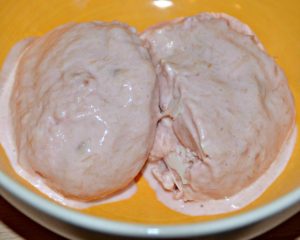 two sccops of pink rhubarb ice cream in a bowl