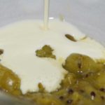 green stewed gooseberries with cream poured over
