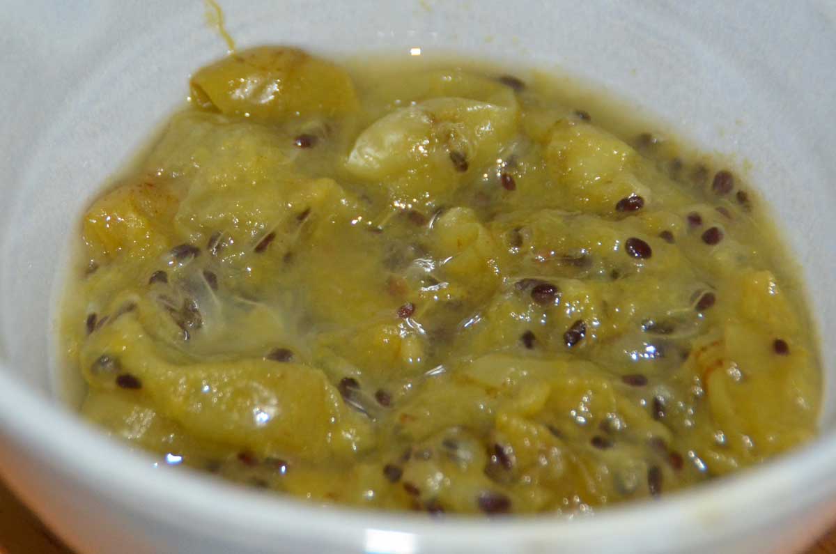 grey bowl with stewed green gooseberries and dark seeds