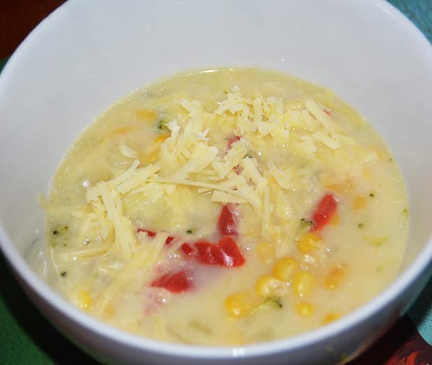 white bowl with soup showing pepper and sweetcorn and sprinkled with cheese