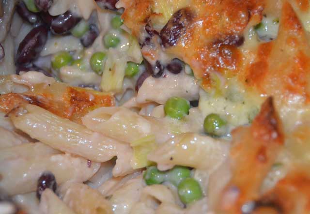 peas and beans in a cheesy sauce on pasta