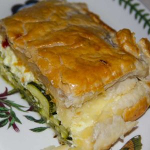 portion of pie in puff pastry showing courgette slices inside