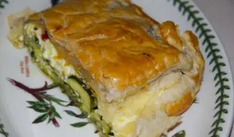 portion of pie in puff pastry showing courgette slices inside