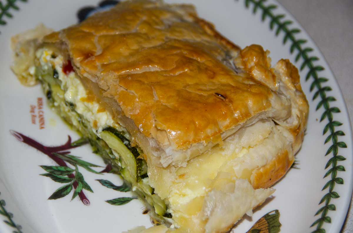 portion of pie in puff pastry showing courgette slices inside