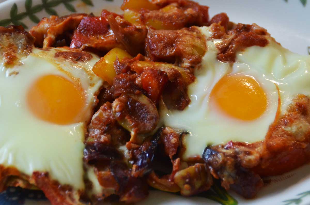 serving of two eggs in tomato and pepper sauce on a plate