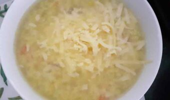 white bowl of soup with grated cheese on top