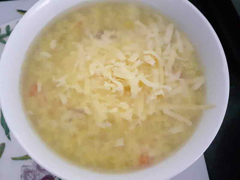 white bowl of soup with grated cheese on top
