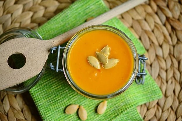 pumpkin soup with wooden spoon on table