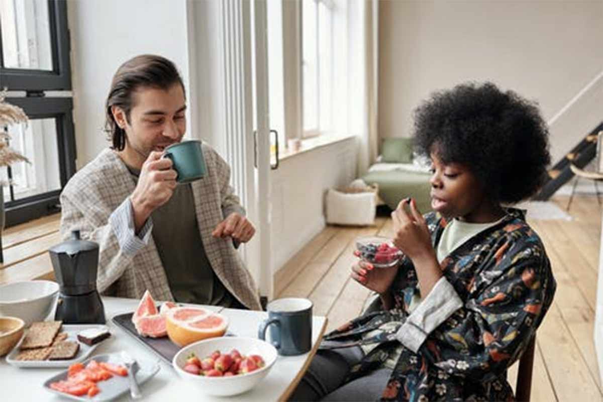 man and woman sitting at a table eating