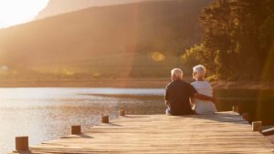 older mand and woman sitting by water