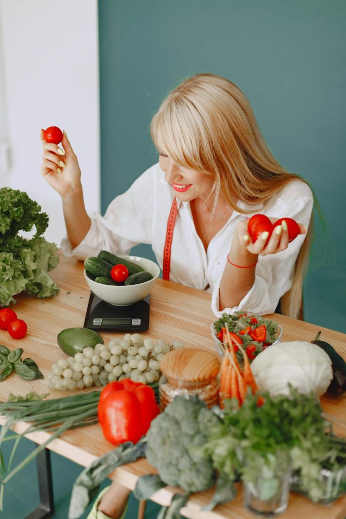 Woman weighing colourful vegetables