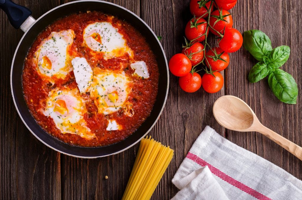 frying pan with tomatoes and eggs cooking