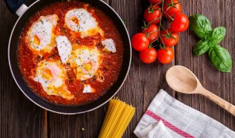 frying pan with tomatoes and eggs cooking